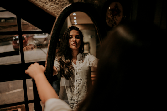 Young woman criticises her image in the mirror